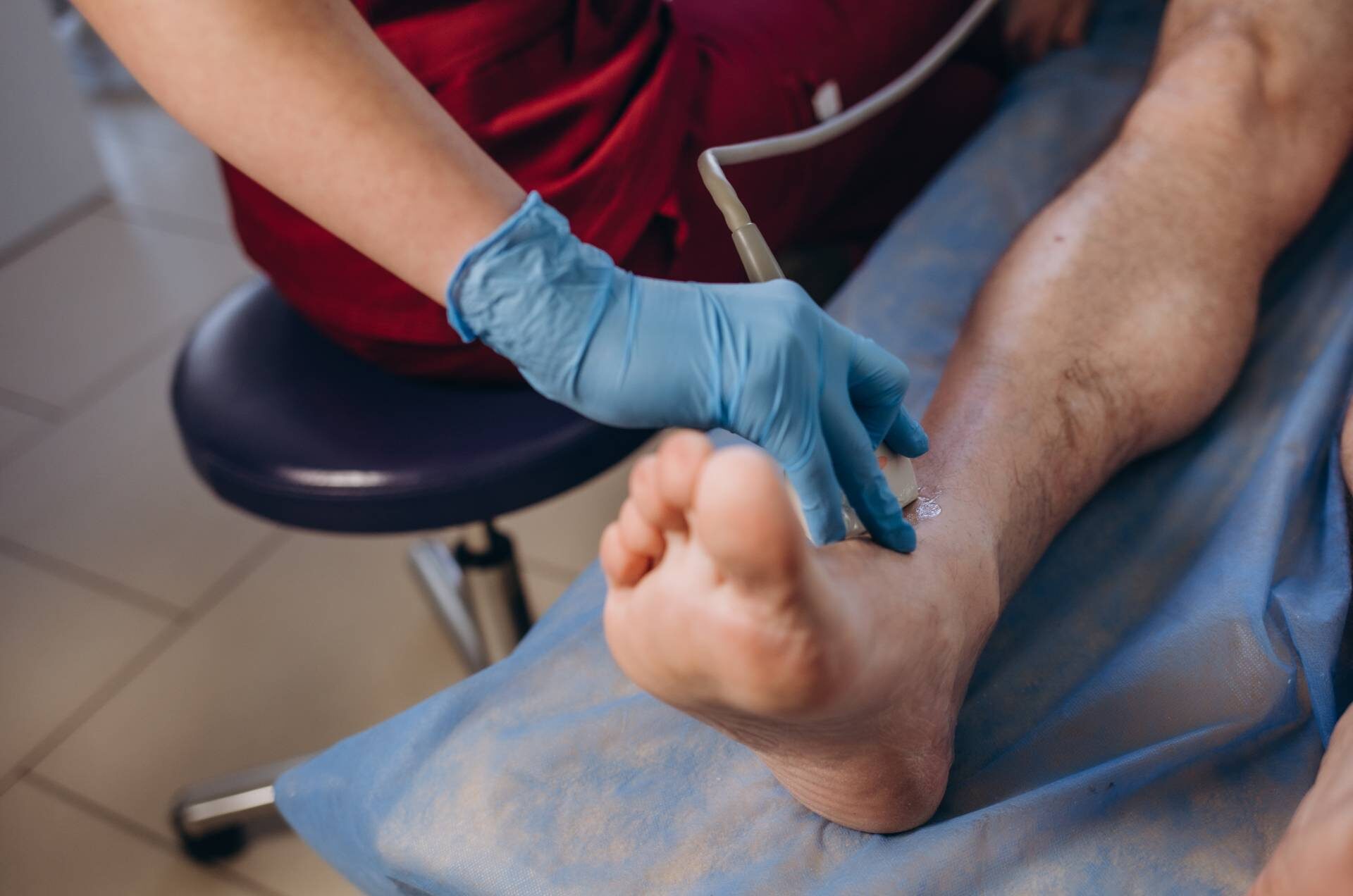 Medical specialist performing doppler ultrasound of the lower limb vessels