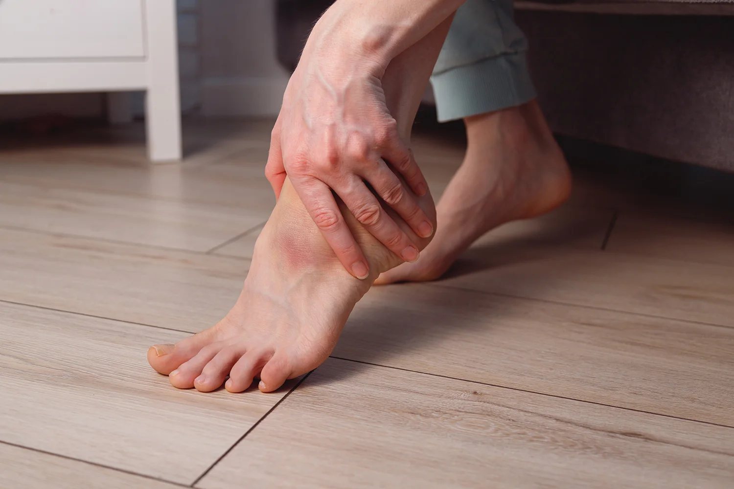 adult woman holding her foot in pain