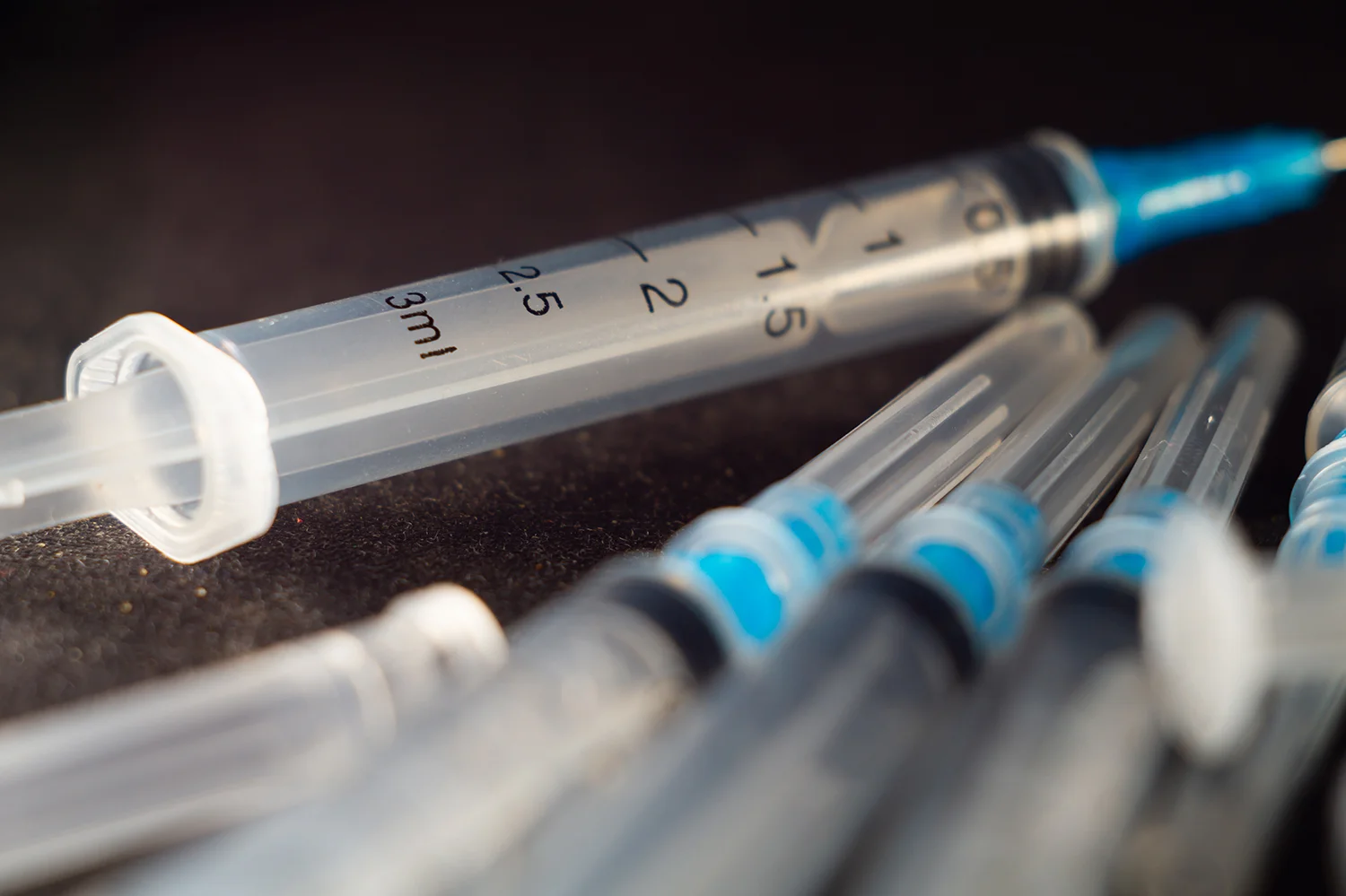 closeup shot of a pile of medical syringes